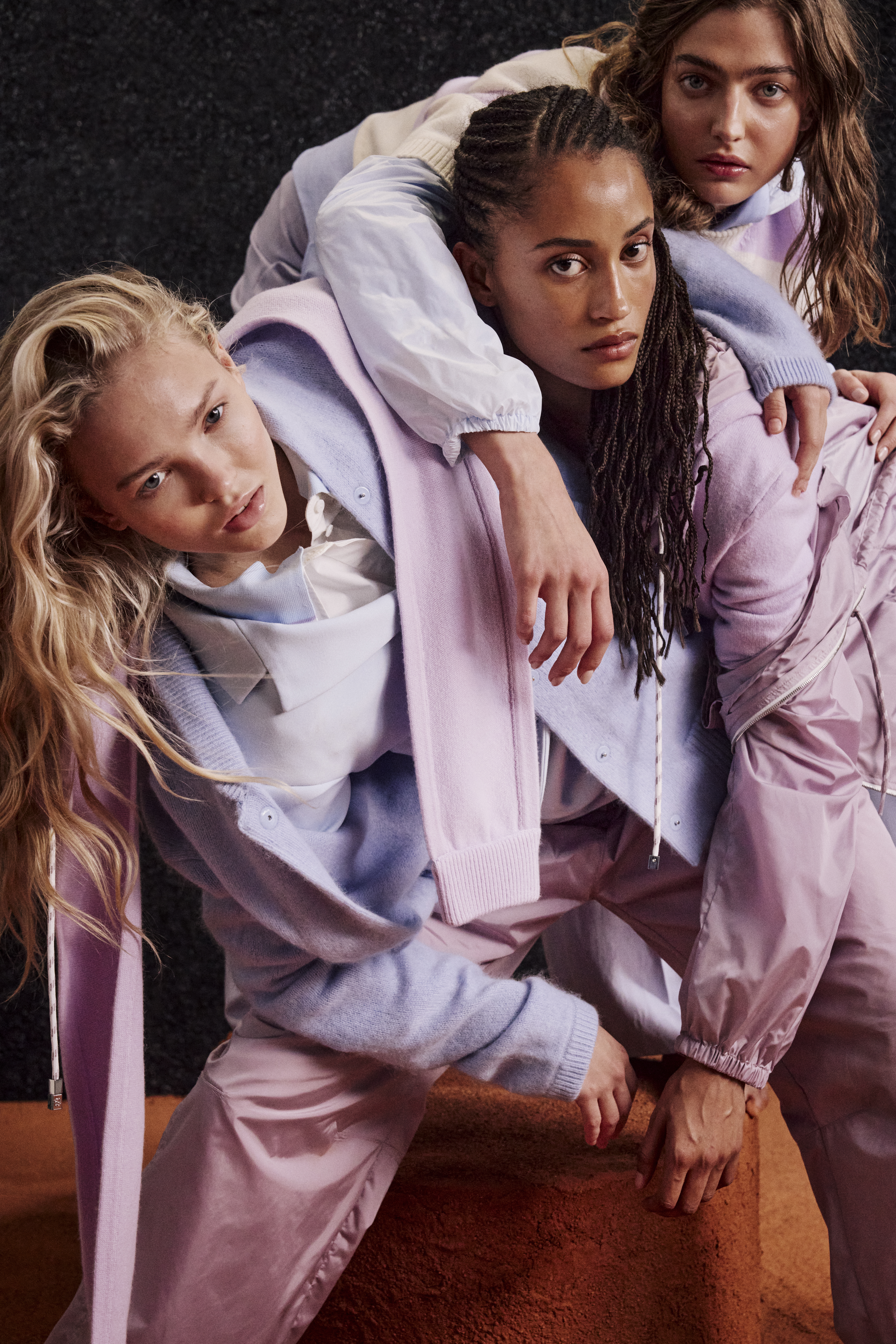 three women looking in the camear wearing baby blue and violet clothes