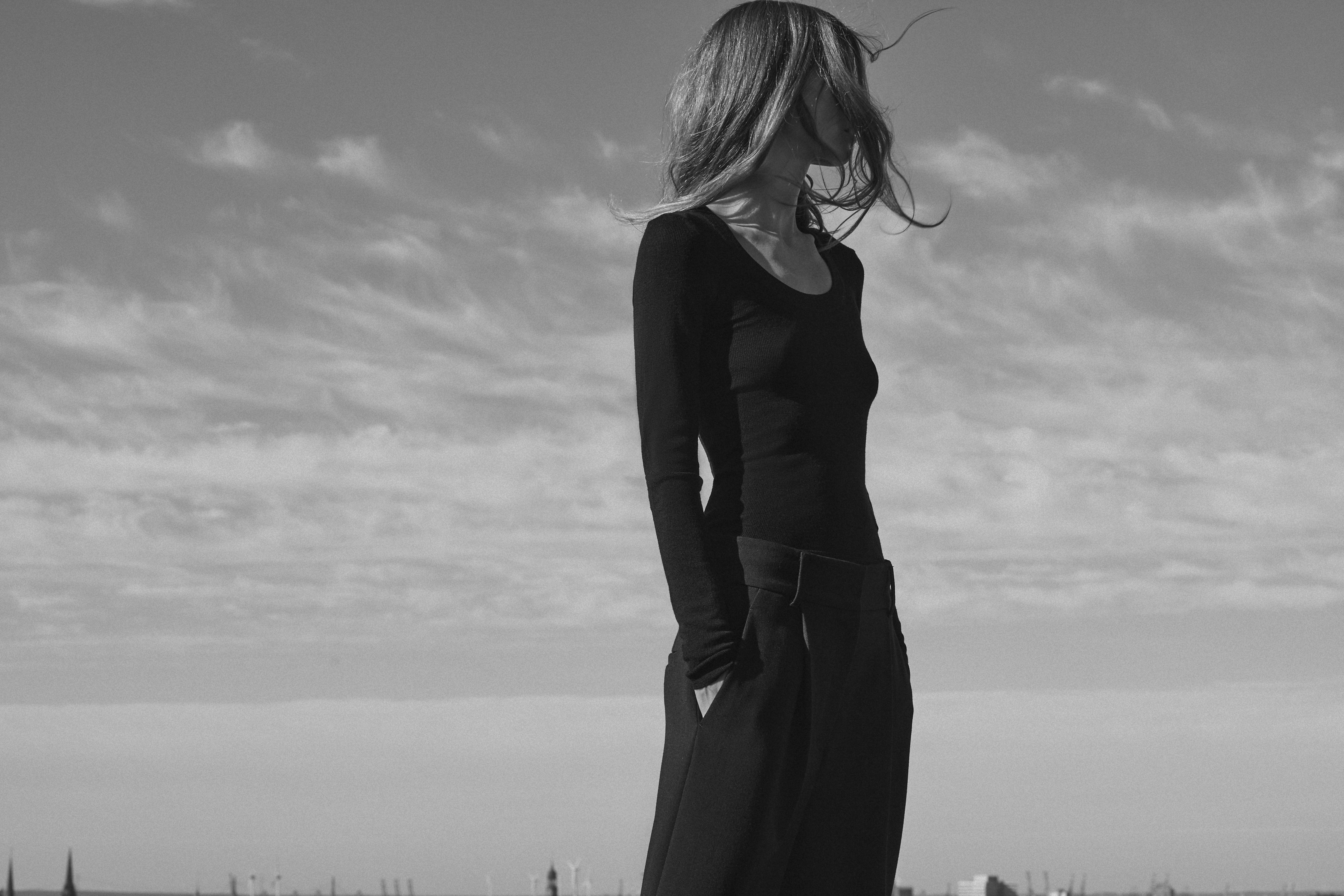 a woman is standing in a black outfit 