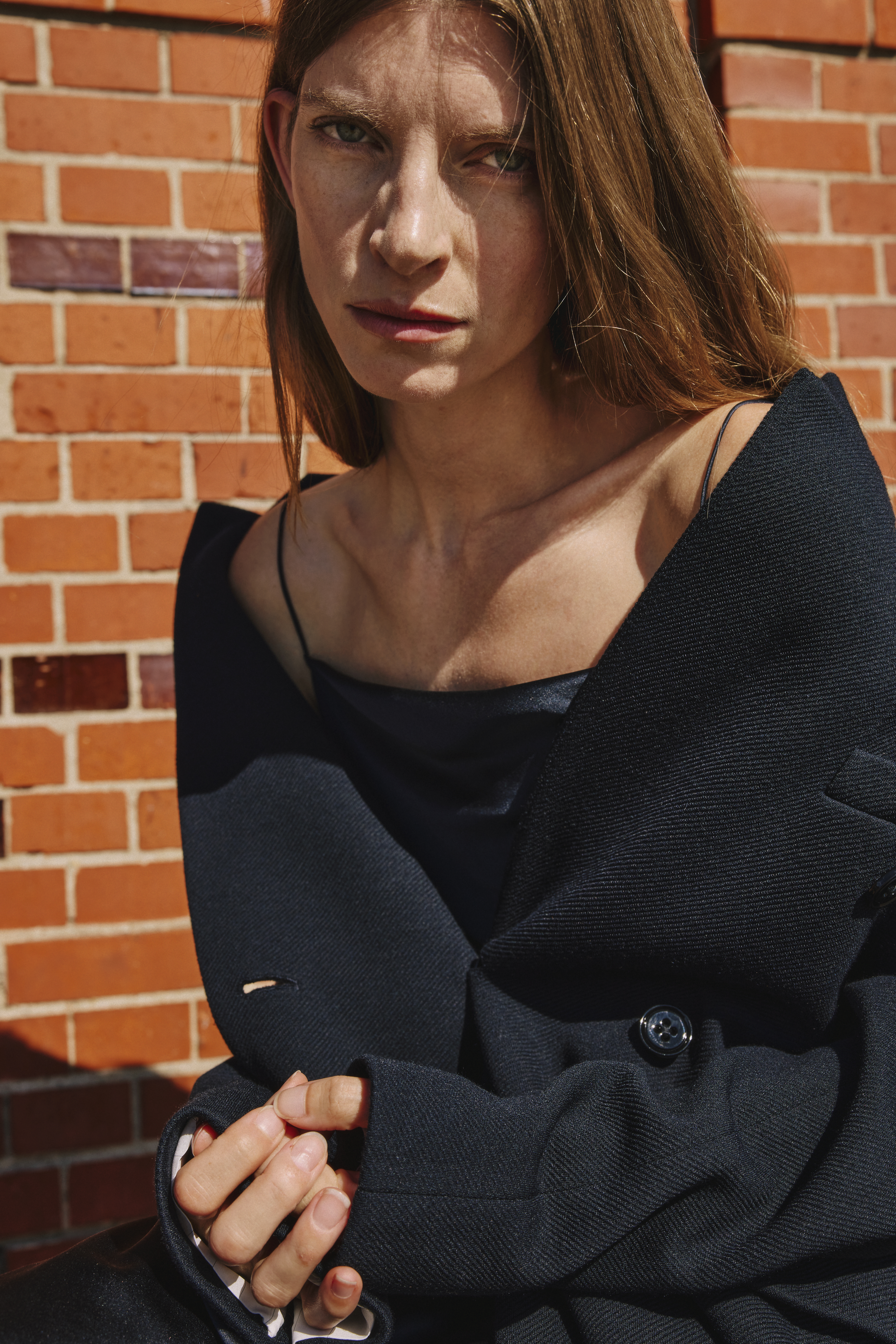 woman is wearing a blue dress and a long coat off shoulder